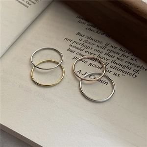 Set di quattro anelli sottili minimalisti in argento, oro e oro rosa su un libro d'epoca