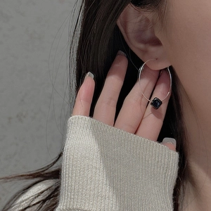 Close-up of S925 silver hoop earring with black square bead on a female model