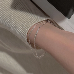 Close-up of minimalist double-layer S925 sterling silver chain bracelet on a wrist
