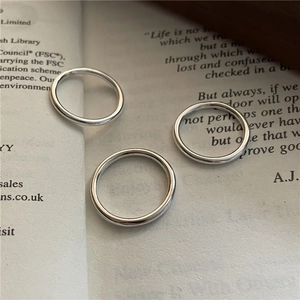 Ensemble de trois bagues minimalistes en argent massif S925 sur pages de livre