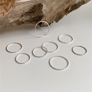 Detailed macro view of S925 sterling silver rings with textured finish on wood