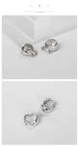 Gros plan de boucles d'oreilles créoles larges en C argentées avec finition miroir poli