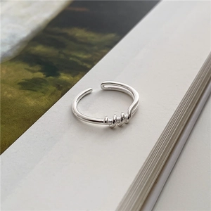 Anello minimalista in argento S925 con triplo intreccio su bordo di un libro
