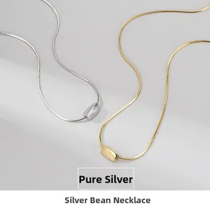 Detailed view of minimalist S925 sterling silver bean pendant on delicate snake chain