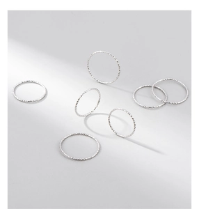 Close-up of S925 sterling silver rings featuring carved textured patterns and metallic luster