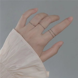 Minimalist S925 sterling silver textured rings set worn by model on a grey background