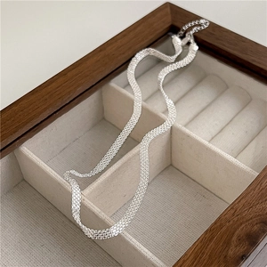 Detail of S925 sterling silver flat woven mesh necklace in dark wooden jewelry box