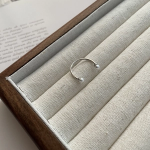 Detailed close-up of S925 silver open smile ring with two white pearls on jewelry tray