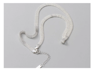 Macro detail of S925 sterling silver woven mesh chain with lobster clasp and extension