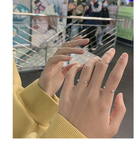Close-up of minimalist S925 silver smile rings with elegant pearls on a female hand