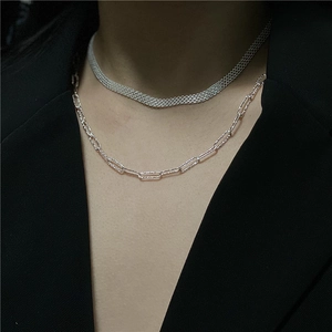 Detail of layered S925 silver wide mesh chain and paperclip necklace on black suit