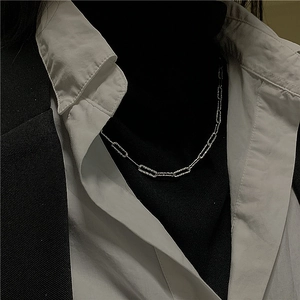 Detail of S925 sterling silver box chain with shimmering diamond-cut texture on clothing