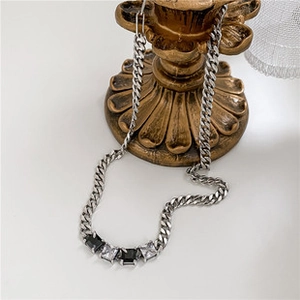 Détail du collier chaîne gourmette argentée avec cristaux carrés noirs et blancs