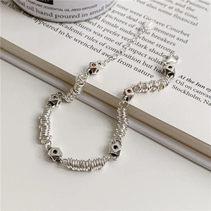Détail d'un bracelet spirale argenté orné de pierres colorées sur un livre ouvert