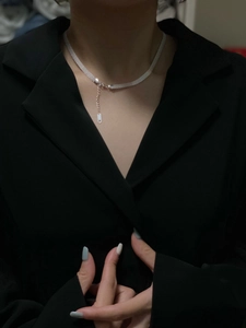 Detailed view of wide silver woven choker with fine mesh texture on model in black suit