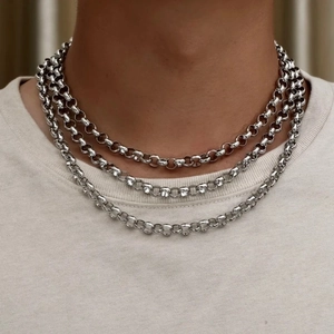 Three-layer silver stainless steel rolo chain necklace worn on a white t-shirt
