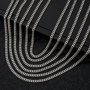 Polished silver stainless steel Cuban link necklaces arranged on a black display base