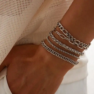 Silver layered bracelet set featuring cuban, paperclip, and wheat link chains on wrist