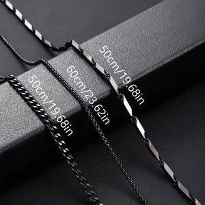 Trois colliers en acier inoxydable noir de 50cm et 60cm sur un présentoir en cuir