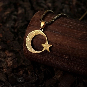 Vintage gold crescent moon and star necklace on natural wood background display
