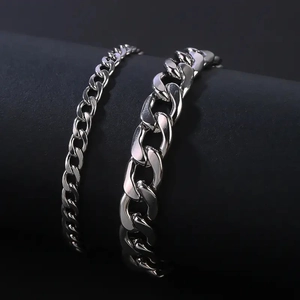 Set of two silver Cuban link chains in 4mm and 8mm widths on a minimalist display