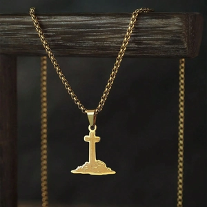 Golden cross pendant necklace with box chain displayed on a professional wooden stand
