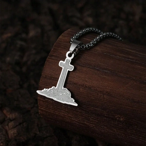 Macro view of vintage stainless steel cross pendant on dark wooden display stand
