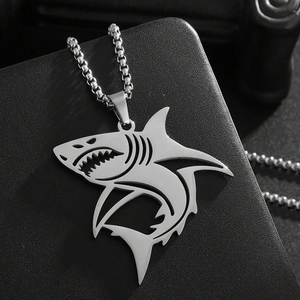 Gros plan d'un pendentif requin en acier inoxydable poli avec détails 3D creux