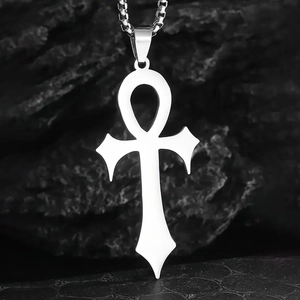 Detailed view of silver stainless steel Ankh cross pendant on a dark rocky surface
