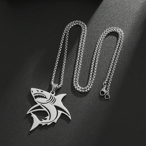 Vue de dessus détaillée du pendentif requin punk ajouré sur une surface mate noire