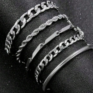 Five-piece silver metal bracelet set featuring Cuban, snake, and curb link chains for layering