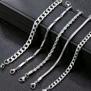 Detailed close-up of 5-piece silver metal bracelet set with cuban and snake chain textures