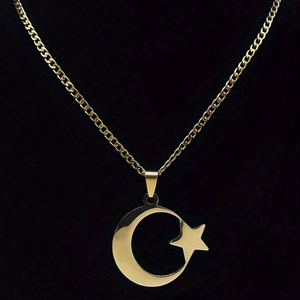 Détail du collier en acier inoxydable doré avec un pendentif poli étoile et lune