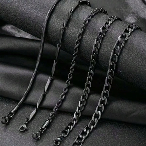 Detail of 5-piece set black stainless steel chains featuring snake and cuban links