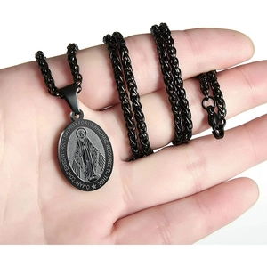 Détail du collier médaillon ovale en acier noir avec portrait de Marie tenu à la main