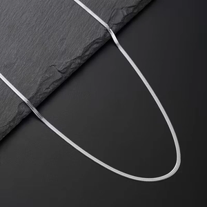 Sleek silver herringbone snake chain necklace for men on minimalist dark rock background