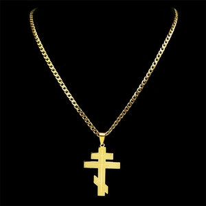Macro detail of golden Orthodox three-bar cross pendant with curb chain necklace