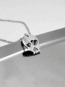 Détail du pendentif crâne avec yeux en cœur et chaîne à billes sur plateau métal