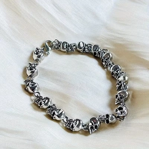 Silver punk skull chain bracelet for men with vintage finish on silk background