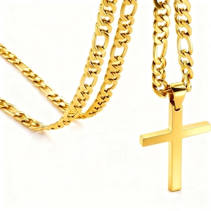 Detailed close-up of a polished gold Figaro chain and cross pendant for men