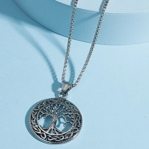 Detailed close-up of a silver Celtic Tree of Life pendant with intricate hollow carvings