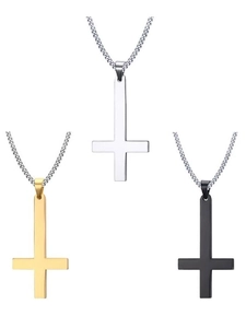 Vue détaillée de pendentifs croix inversés en argent, or et noir sur chaînes