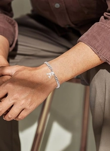 Silver Cuban link bracelet featuring a gothic capital letter A pendant on a wrist