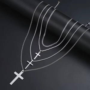 Polished stainless steel cross necklaces with assorted metal chains on a display stand