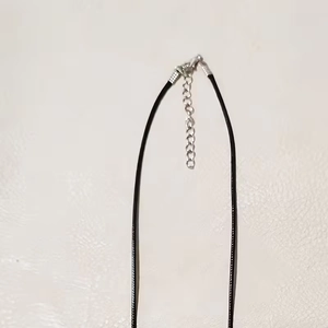 Detail of black PU leather cord with silver lobster clasp and extension chain for necklaces