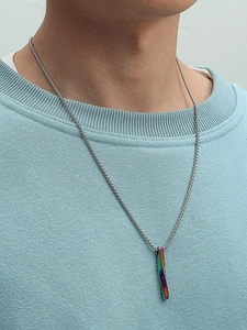 Nahaufnahme eines regenbogenfarbenen Drehbalken-Anhängers an einer Silberkette