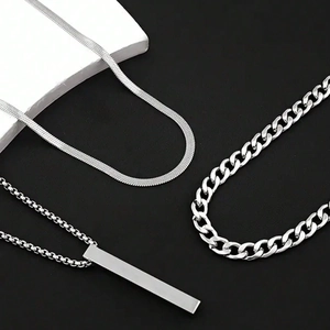 Close-up of stainless steel curb chain, snake chain, and rectangular pendant set for men