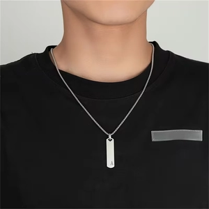Détail du pendentif rectangle argenté avec lettre A sur chaîne en acier pour homme