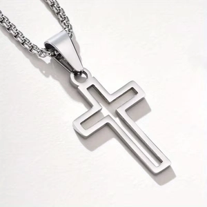 Close-up of a hollow double-frame stainless steel cross pendant on a box chain