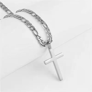 Detailed view of a polished stainless steel cross pendant on a Figaro style chain